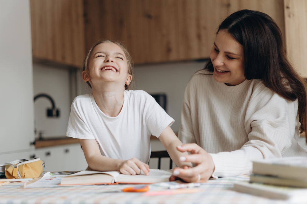 A,Young,Mother,And,Happy,Daughter,Studying,Together,At,A